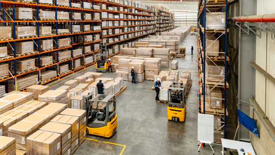 Aerial view of employees working at a distribution warehouse moving merchandise